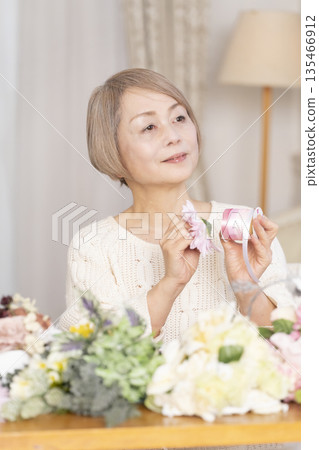 一位老婦人在客廳以插花為樂 135466912