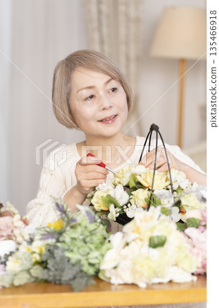 一位老婦人在客廳以插花為樂 135466918