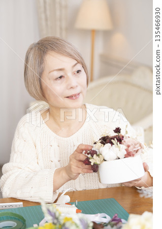 一位老婦人在客廳以插花為樂 135466930