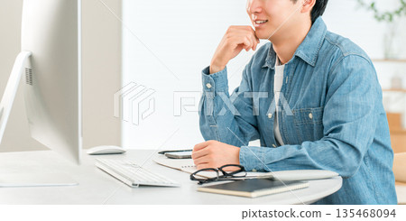A man using a computer at home to telework, online seminar, side job, video editing A man using a computer at home to telework, online seminar, side job, video editing 135468094