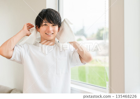 Young Asian man towel drying his hair after shower Young Asian man towel drying his hair after shower 135468226