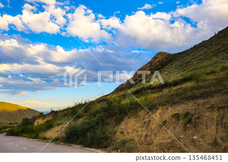 Winding paved road through serene countryside landscape Winding paved road through serene countryside landscape 135468451