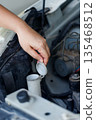 Close up of a hand of woman is checking a liquid coolant pot 135468512