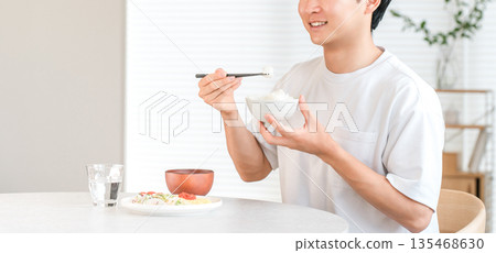 桌上的米飯,一位年輕的亞洲男子正在吃白米飯(物價上漲,物價上漲,價格上漲) 桌上的米飯,一位年輕的亞洲男子正在吃白米飯(物價上漲,物價上漲,價格上漲) 135468630