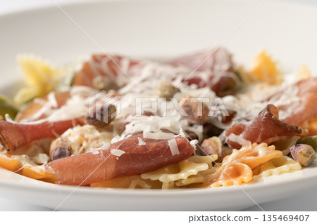 Farfalle pasta with pork coppa and parmesan cheese 135469407