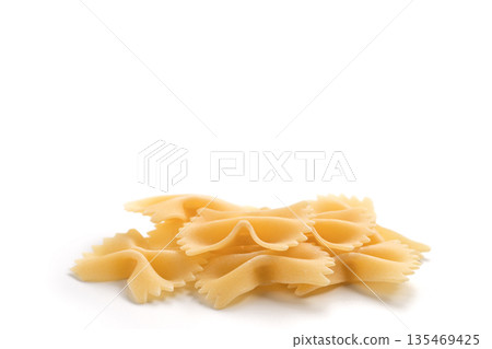 Italian dry farfalle pasta over white background with shadow top view 135469425