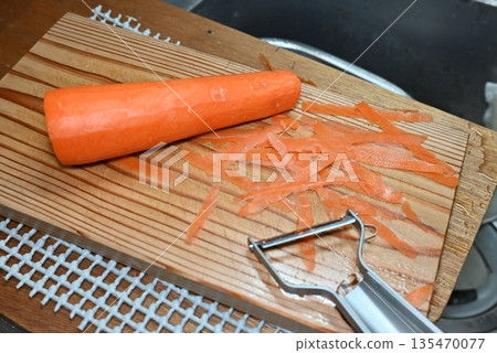 Peeling carrots with a peeler Peeling carrots with a peeler 135470077