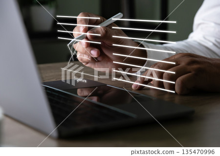 Electronic signature concept, businessman signs document on a laptop, secure e signing, document contract approval, identity verification 135470996