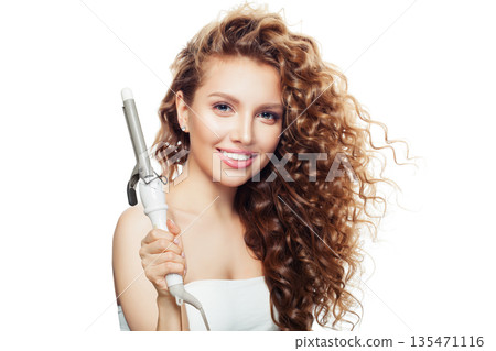 Isolated woman holding using hot curling tongs iron on white background.  135471116