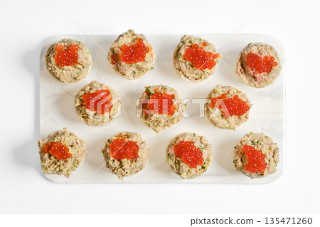 Delicious tuna tartlets topped with vibrant caviar on a clean white platter Delicious tuna tartlets topped with vibrant caviar on a clean white platter 135471260