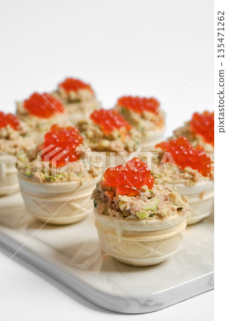 Tuna tartlets with red caviar served on a white platter for a stylish appetizer display Tuna tartlets with red caviar served on a white platter for a stylish appetizer display 135471262
