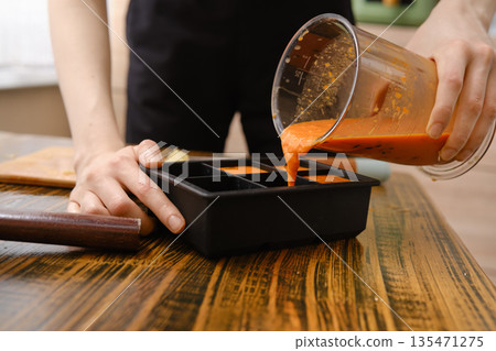 Preparing frozen vitamin fruit beverage in a kitchen with a blender and a container on a wooden table 135471275