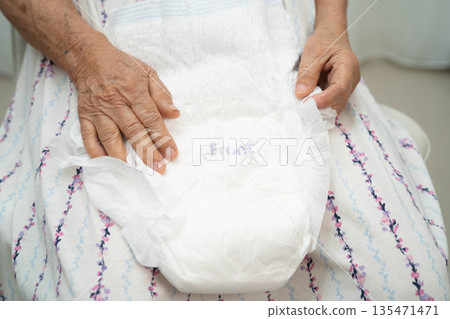 Asian senior woman patient wearing adult incontinence diaper pad in hospital. Asian senior woman patient wearing adult incontinence diaper pad in hospital. 135471471