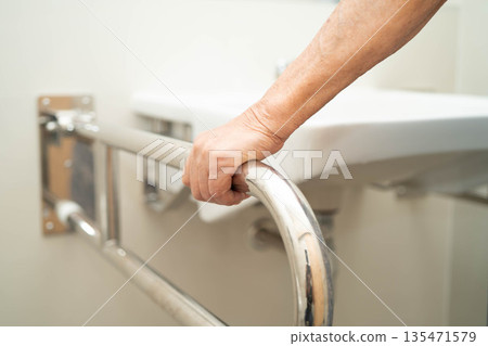Asian elderly woman use safety handrail in bathroom. Asian elderly woman use safety handrail in bathroom. 135471579