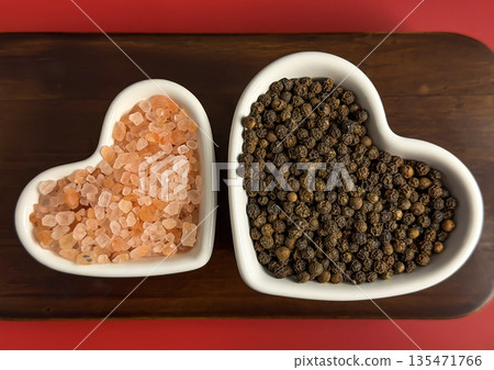 Heart-Shaped Bowls with Pink Himalayan Salt and Black Peppercorns on Wooden Background Heart-Shaped Bowls with Pink Himalayan Salt and Black Peppercorns on Wooden Background 135471766