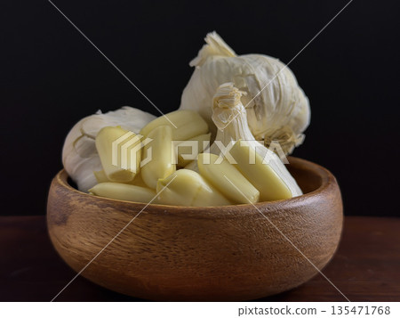 Fresh Garlic Cloves in Wooden Bowl on Dark Background 135471768