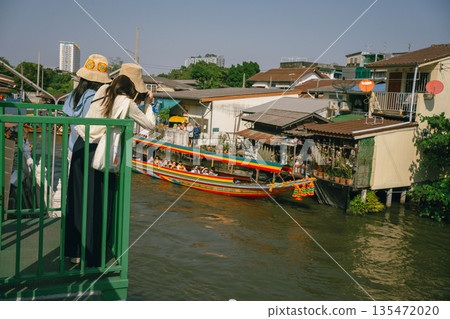 asia travel with people travel and take picture with large buddhist and beautiful temple with river at Bangkok Thailand in summer season 135472020