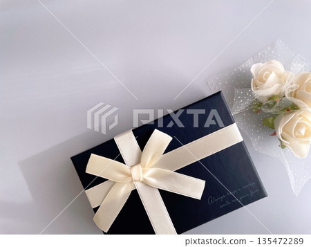 淺藍色背景,上面有禮物和白玫瑰 淺藍色背景,上面有禮物和白玫瑰 135472289