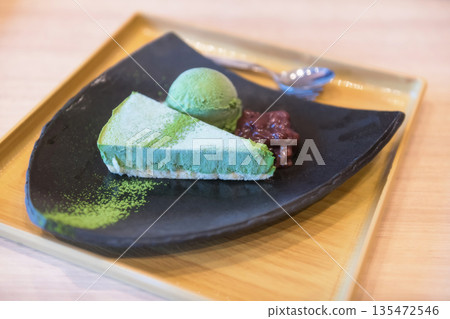 Matcha green tea cake with ice cream and red bean on wooden table 135472546