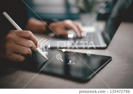 Hand using digital pen on tablet with laptop and digital communication icons concept Hand using digital pen on tablet with laptop and digital communication icons concept 135472798