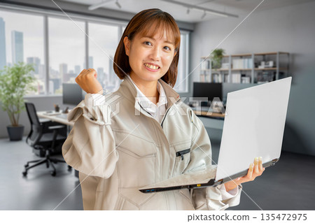 一名女子對著電腦揮拳慶祝。 一名女子對著電腦揮拳慶祝。 135472975