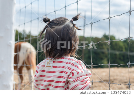 [正在吃草的馬和兩歲小孩] 135474033