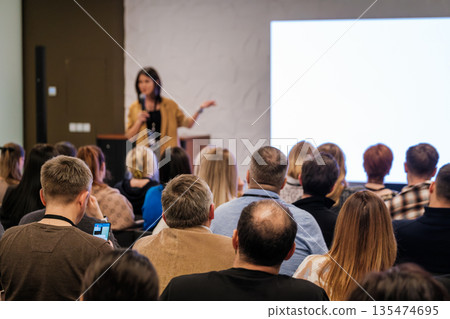Speaker presents to engaged audience at conference sharing insights and ideas on stage Speaker presents to engaged audience at conference sharing insights and ideas on stage 135474695