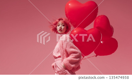 A woman is holding a heart balloon 135474938