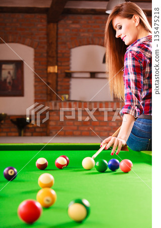 Young fashionable girl playing billiard. 135475218