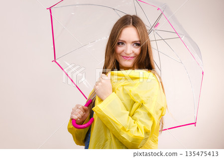 Woman wearing waterproof coat under umbrella Woman wearing waterproof coat under umbrella 135475413