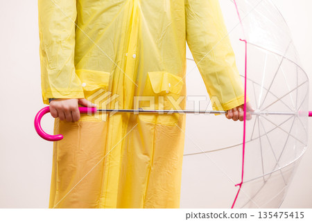 Woman wearing waterproof coat holding umbrella Woman wearing waterproof coat holding umbrella 135475415