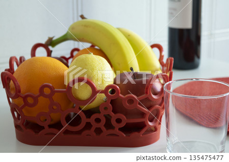 fruit bowl centerpiece with wine on modern kitchen table 135475477