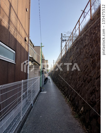 日本某城市的一條靜謐小路沿著鐵軌蜿蜒而行 日本某城市的一條靜謐小路沿著鐵軌蜿蜒而行 135475512