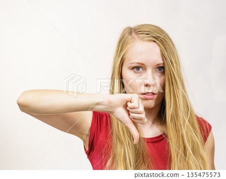 Girl giving thumb down Girl giving thumb down 135475573