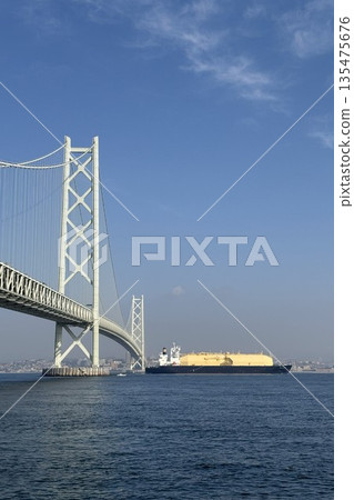 遠處可以看到一艘巨大的液化天然氣運輸船正駛過明石海峽大橋。 遠處可以看到一艘巨大的液化天然氣運輸船正駛過明石海峽大橋。 135475676