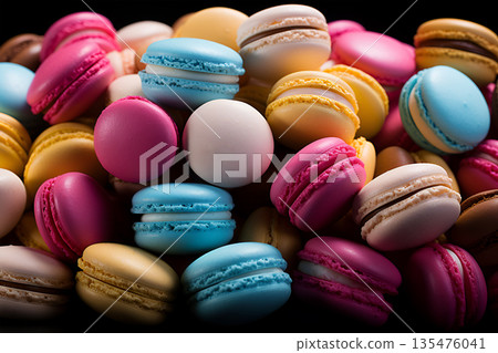A lot of beautiful French sweets macaroons of yellow and pink colors with patterns lie in rows in assortment in a bakery 135476041