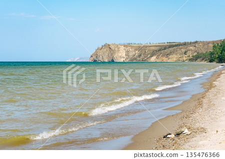 Rocky shore of Olkhon island on Baikal lake with sandy beach and wave. Concept of travel, nature, Siberia, Russia, vacation. 135476366