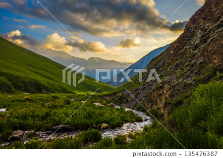 Majestic sunset over serene river and mountains 135476387