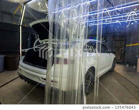 White sedan with open trunk in car wash at night White sedan with open trunk in car wash at night 135476843
