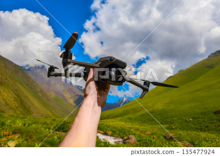 Drone held above lush mountains and river in bright daylight 135477924