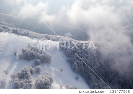 Aerial winter view of foggy mountains Aerial winter view of foggy mountains 135477968