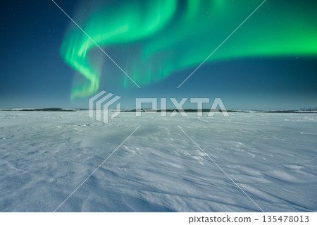 Open snowy wilderness under glowing northern lights Open snowy wilderness under glowing northern lights 135478013