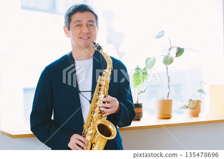 Man playing the saxophone at home Man playing the saxophone at home 135478696