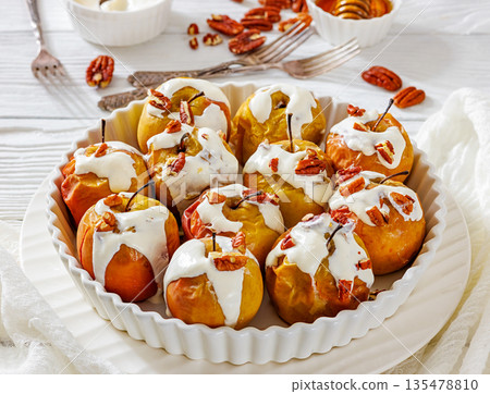 Tasty Baked Apples with Pecans and Cream 135478810