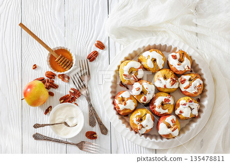 Tasty Baked Apples with Pecans and Cream Tasty Baked Apples with Pecans and Cream 135478811
