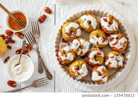Tasty Baked Apples with Pecans and Cream 135478813