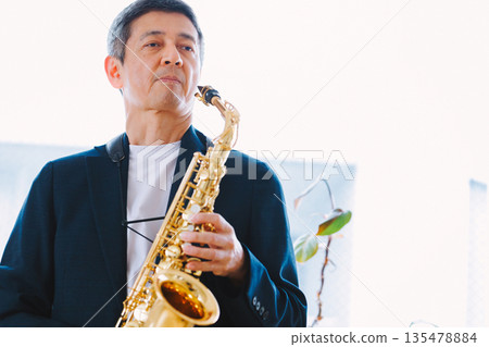 Man playing the saxophone at home Man playing the saxophone at home 135478884