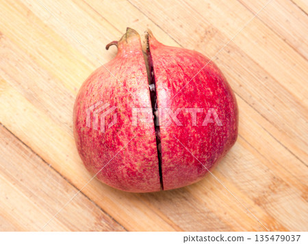 Cut ripe pomegranate on an old wooden table. Cut ripe pomegranate on an old wooden table. 135479037