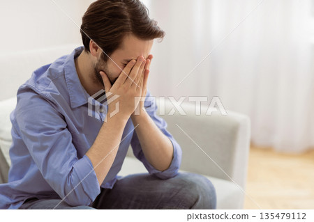 Male Depression. Frustrated Man Crying Covering Face Sitting On Sofa At Home. Desperate Guy Cries In Living Room. Unhappiness And Stressful Modern Life Concept. Empty Space For Text Male Depression. Frustrated Man Crying Covering Face Sitting On Sofa At Home. Desperate Guy Cries In Living Room. Unhappiness And Stressful Modern Life Concept. Empty Space For Text 135479112