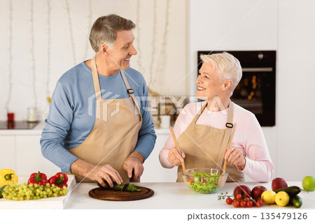 Cheerful Aged Couple Cooking Salad Preparing Dinner In Modern Kitchen At Home. Senior Spouses Enjoying Food Preparation Together. Healthy Nutrition Recipes, Dieting In Older Age Concept 135479126